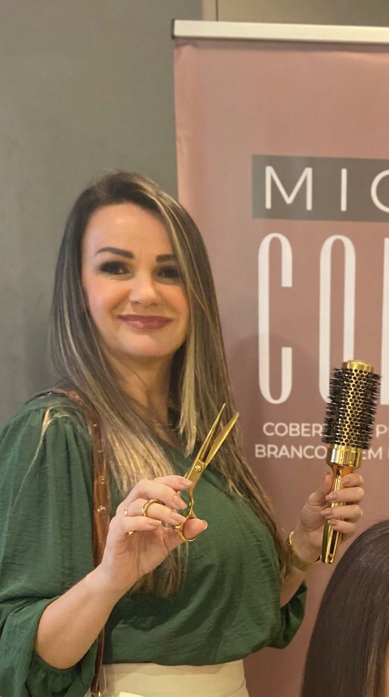Marisa Girelli, cabeleireira, sorrindo segurando uma tesoura dourada e uma escova dourada de cabelo